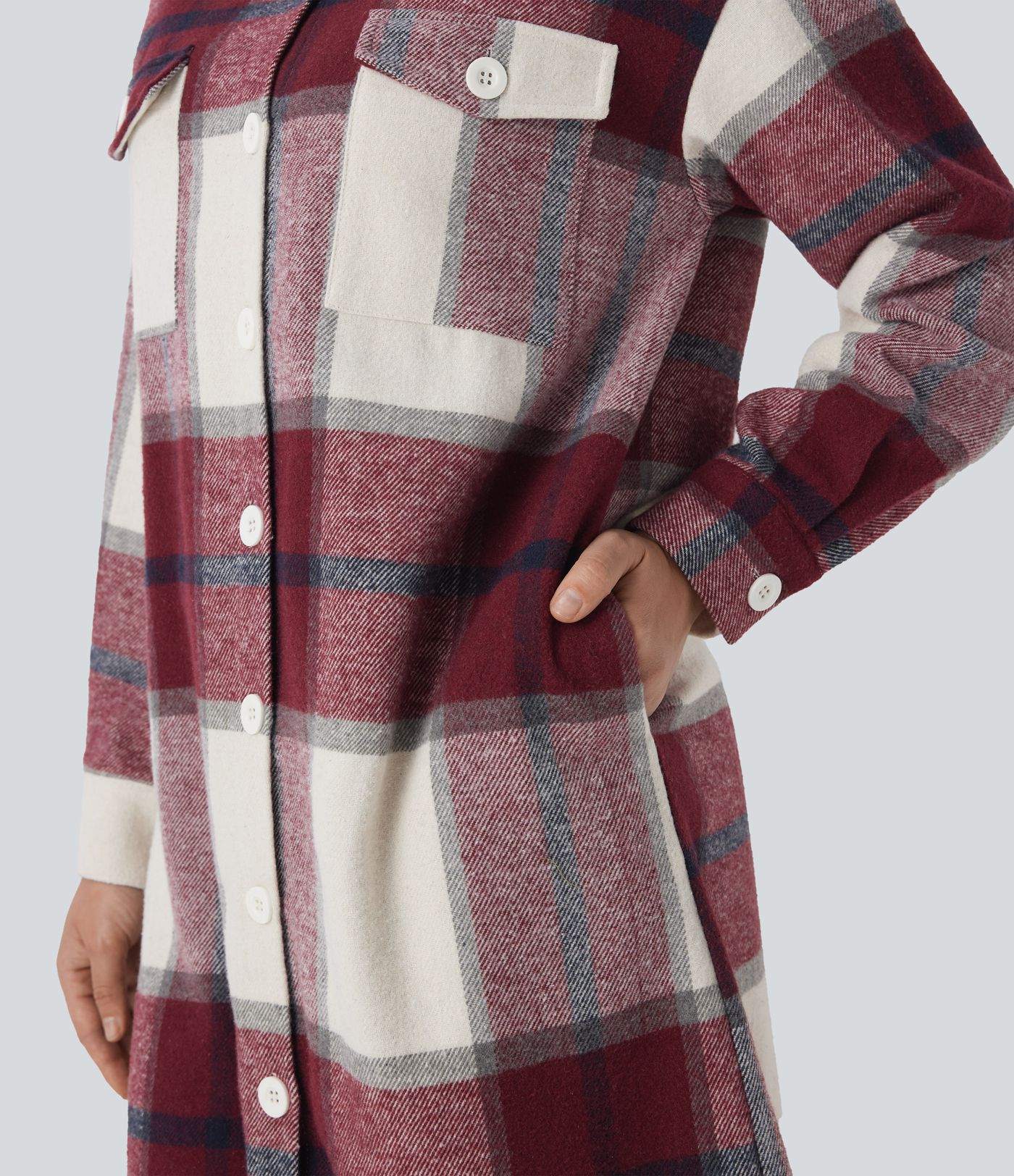 Dlouhá kostkovaná bunda s několika kapsami a zaoblenými lemy