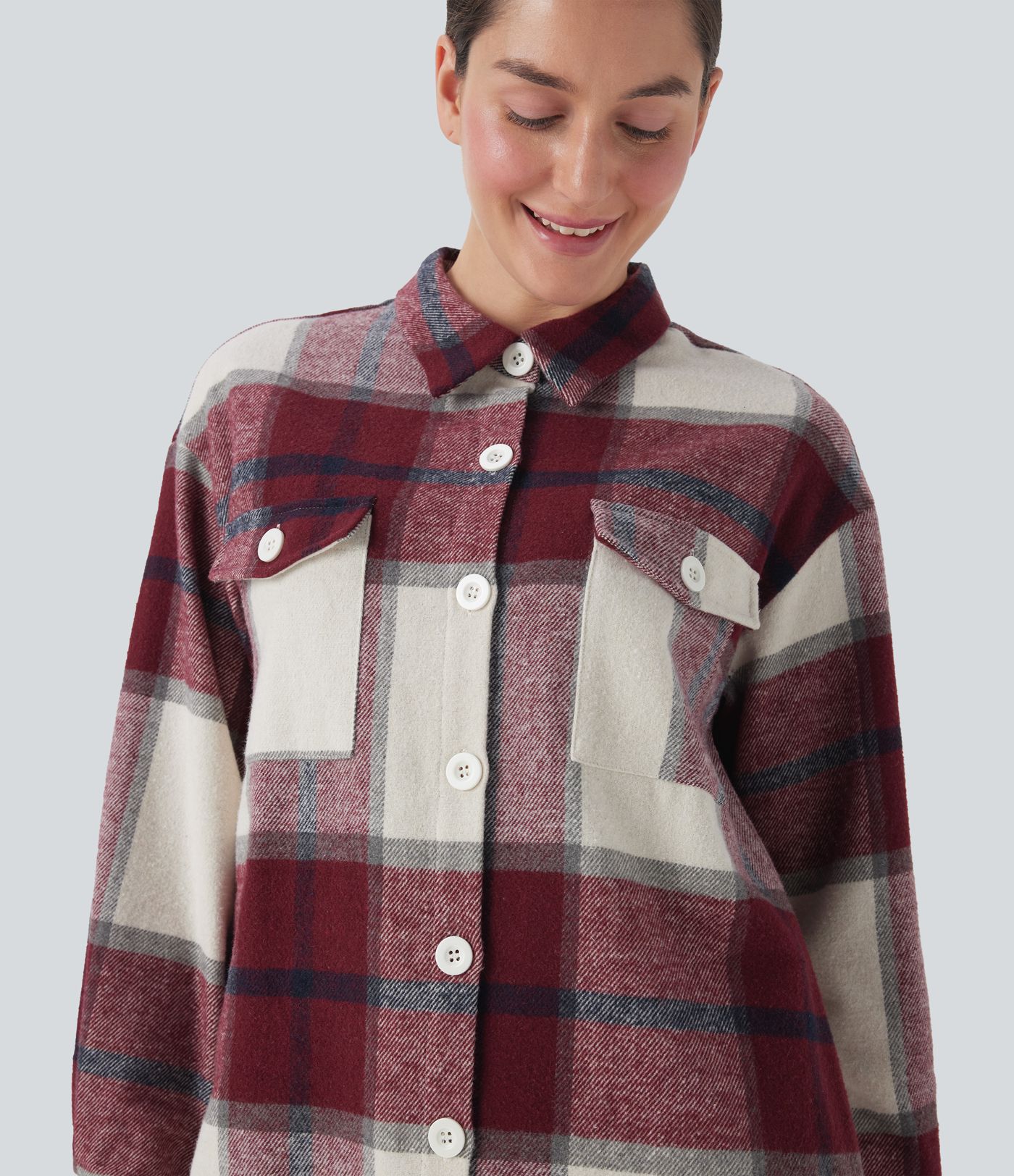 Dlouhá kostkovaná bunda s několika kapsami a zaoblenými lemy