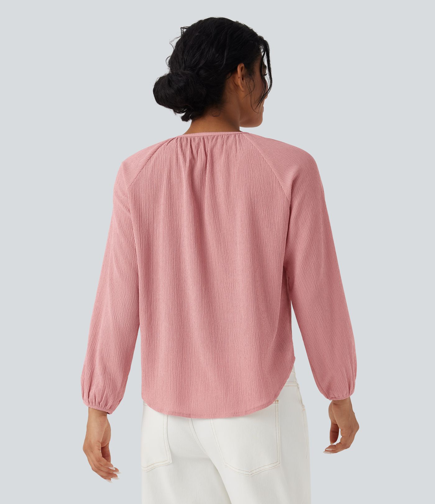 Blusa casual texturizada com decote redondo, mangas longas e barra curva.