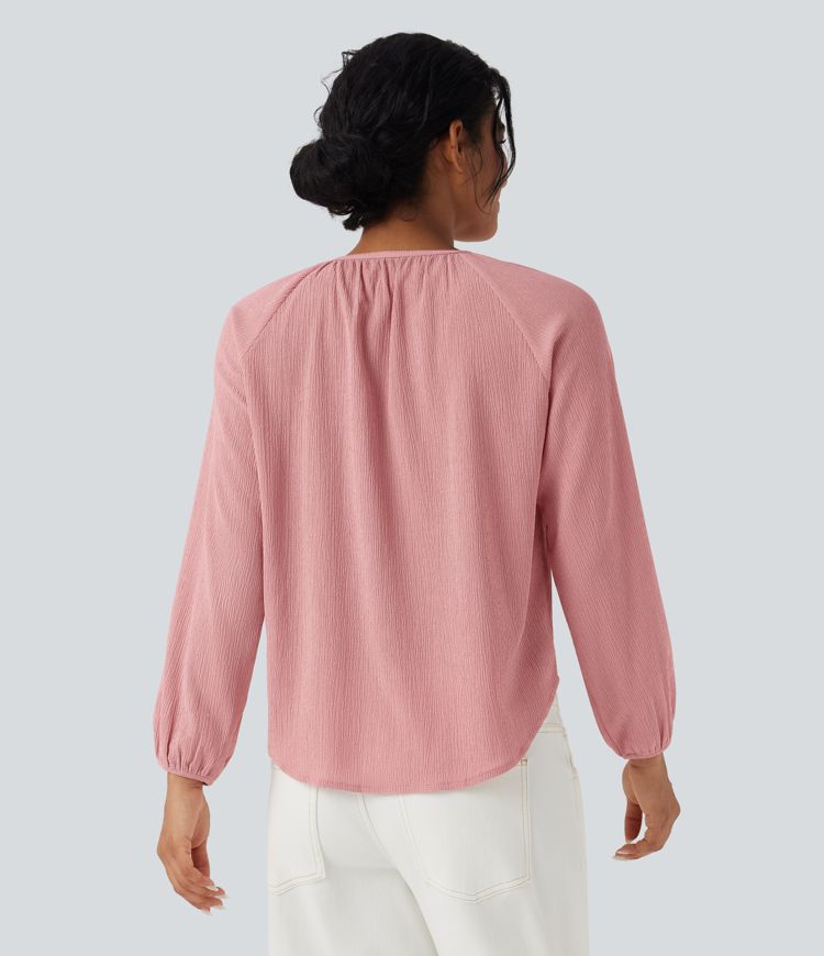 Blusa casual texturizada com decote redondo, mangas longas e barra curva.