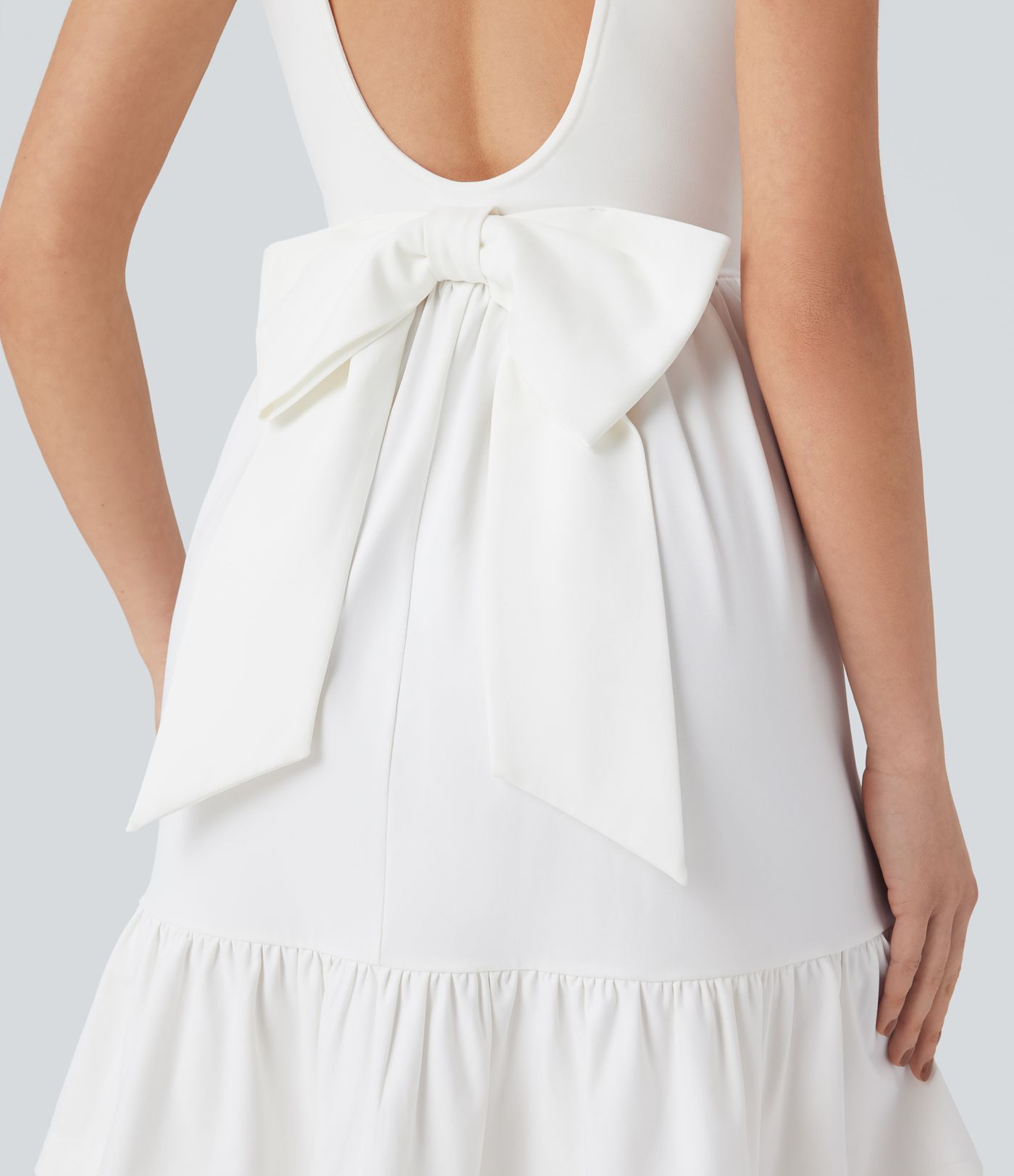 Mini dress with boat neck, low back, and bow