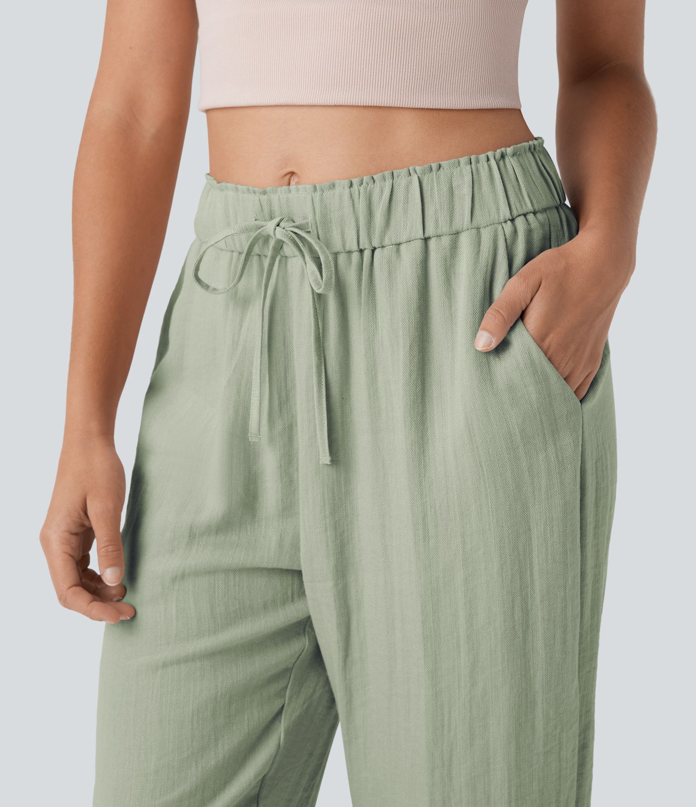 Közepes derekú, lezser, szűkülő fazonú nadrág zsínorokkal és zsebekkel