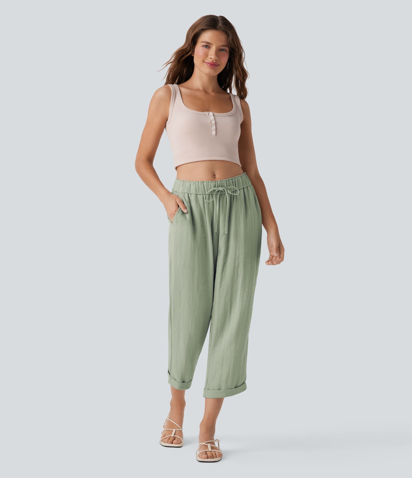 Közepes derekú, lezser, szűkülő fazonú nadrág zsínorokkal és zsebekkel