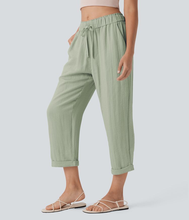 Közepes derekú, lezser, szűkülő fazonú nadrág zsínorokkal és zsebekkel