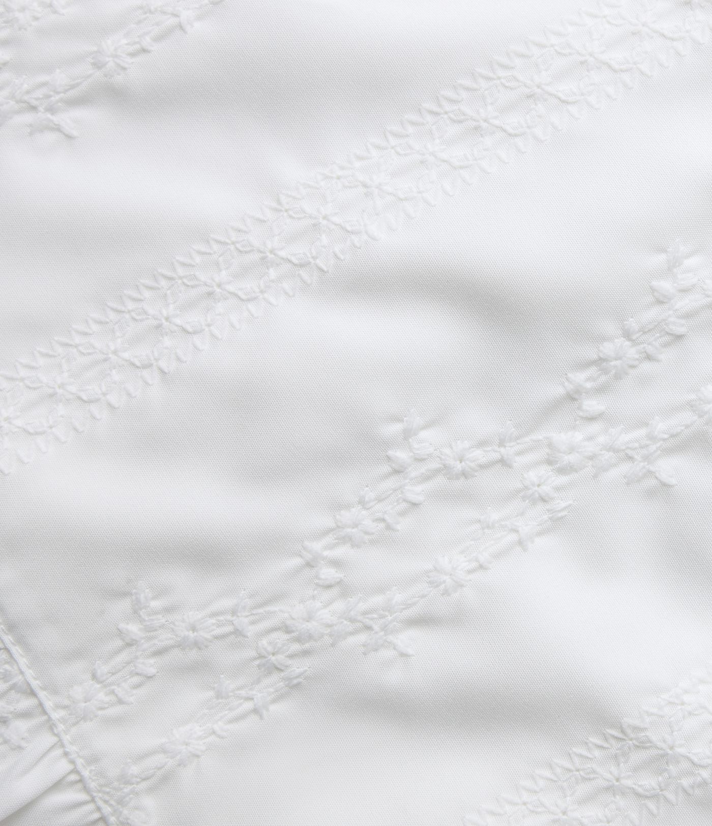 Top sin mangas estilo resort con escote en V, bordado y bajo con volante