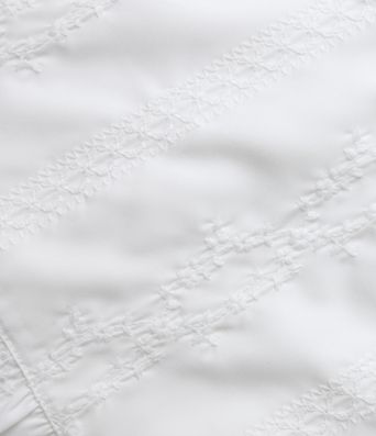 Top sin mangas estilo resort con escote en V, bordado y bajo con volante