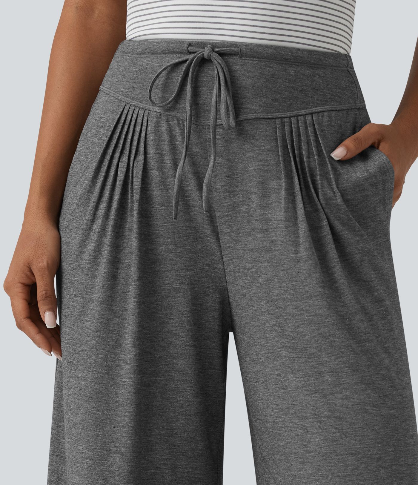 Pantalones casuales anchos de talle alto con cordón, plisados, de tejido jaspeado y con bolsillos.