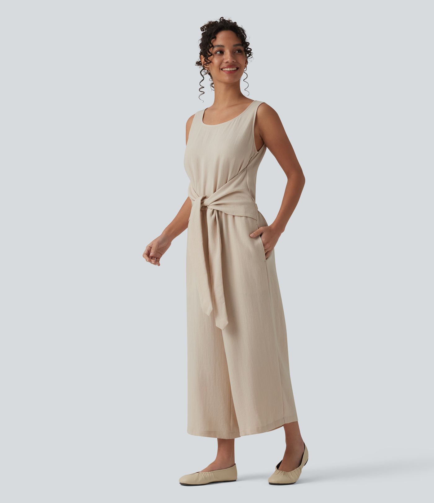 Afslappet ærmeløs jumpsuit med rund hals, bindebånd foran, linned-look og lommer — nemt som en leg