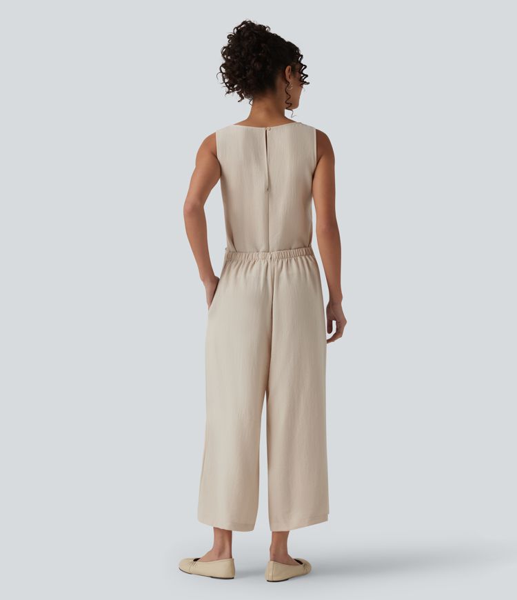 Afslappet ærmeløs jumpsuit med rund hals, bindebånd foran, linned-look og lommer — nemt som en leg