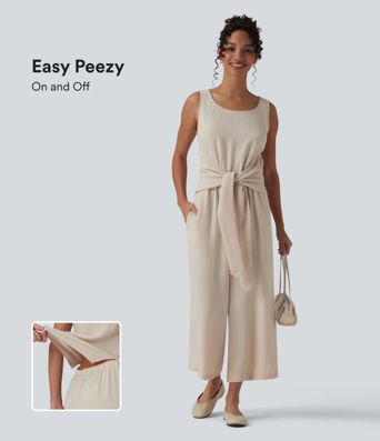 Afslappet ærmeløs jumpsuit med rund hals, bindebånd foran, linned-look og lommer — nemt som en leg