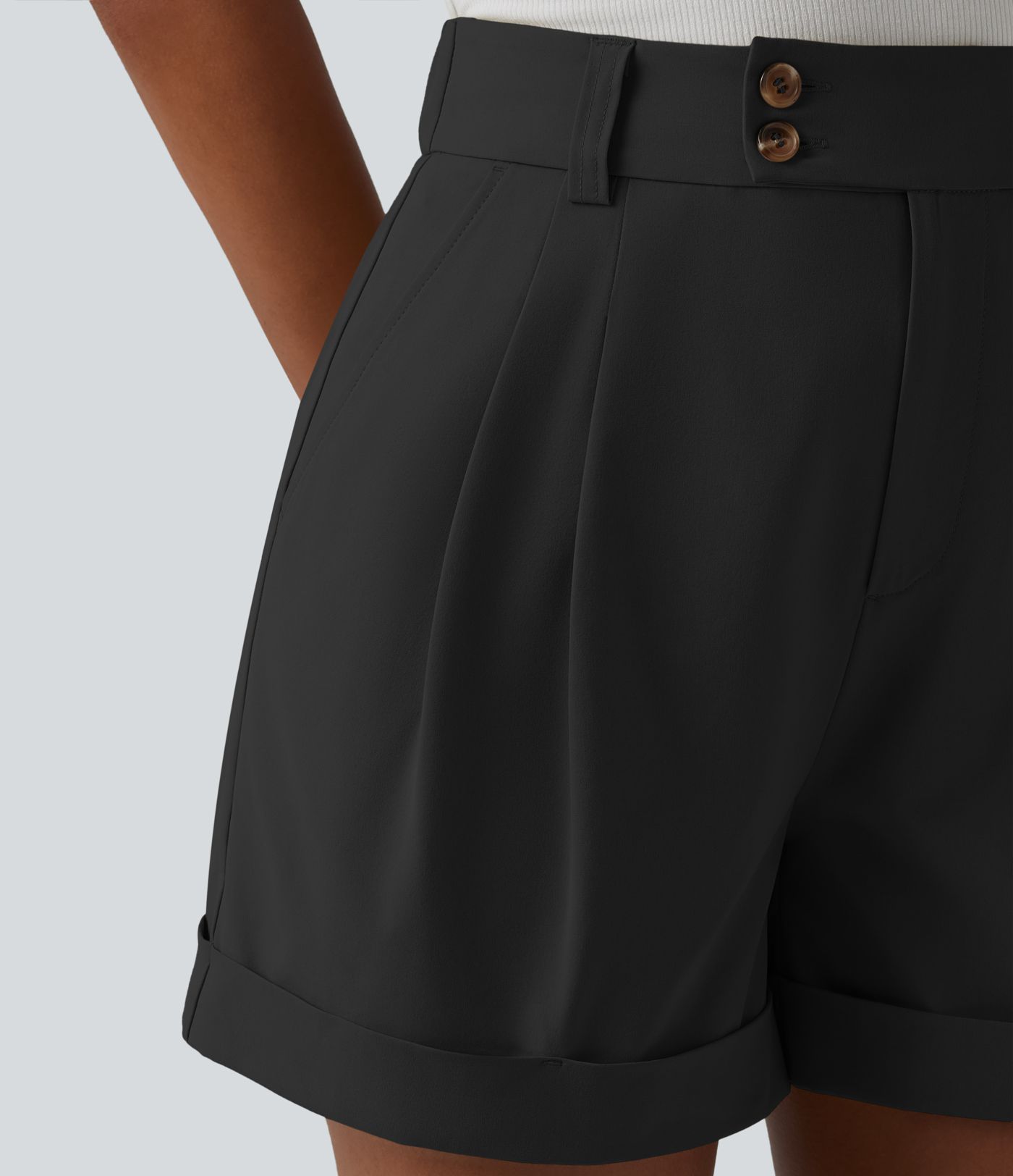 Pleated baggy office shorts made of elastic poplin with a high waist, side pockets and a folded-over waistband.