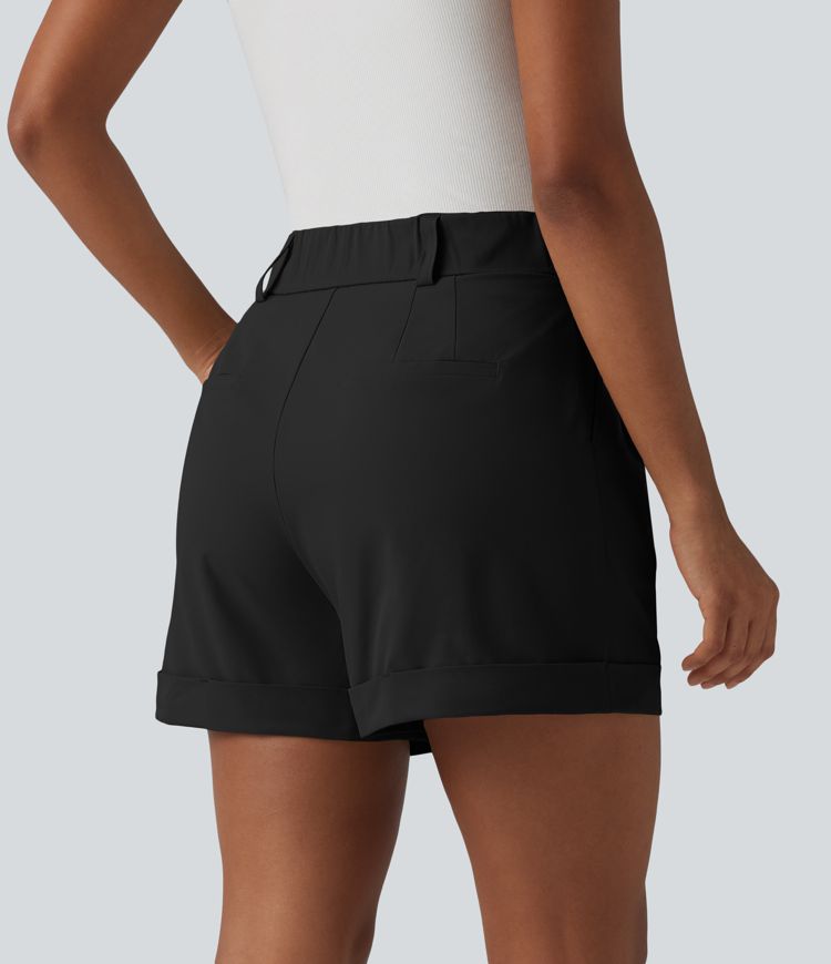 Pleated baggy office shorts made of elastic poplin with a high waist, side pockets and a folded-over waistband.