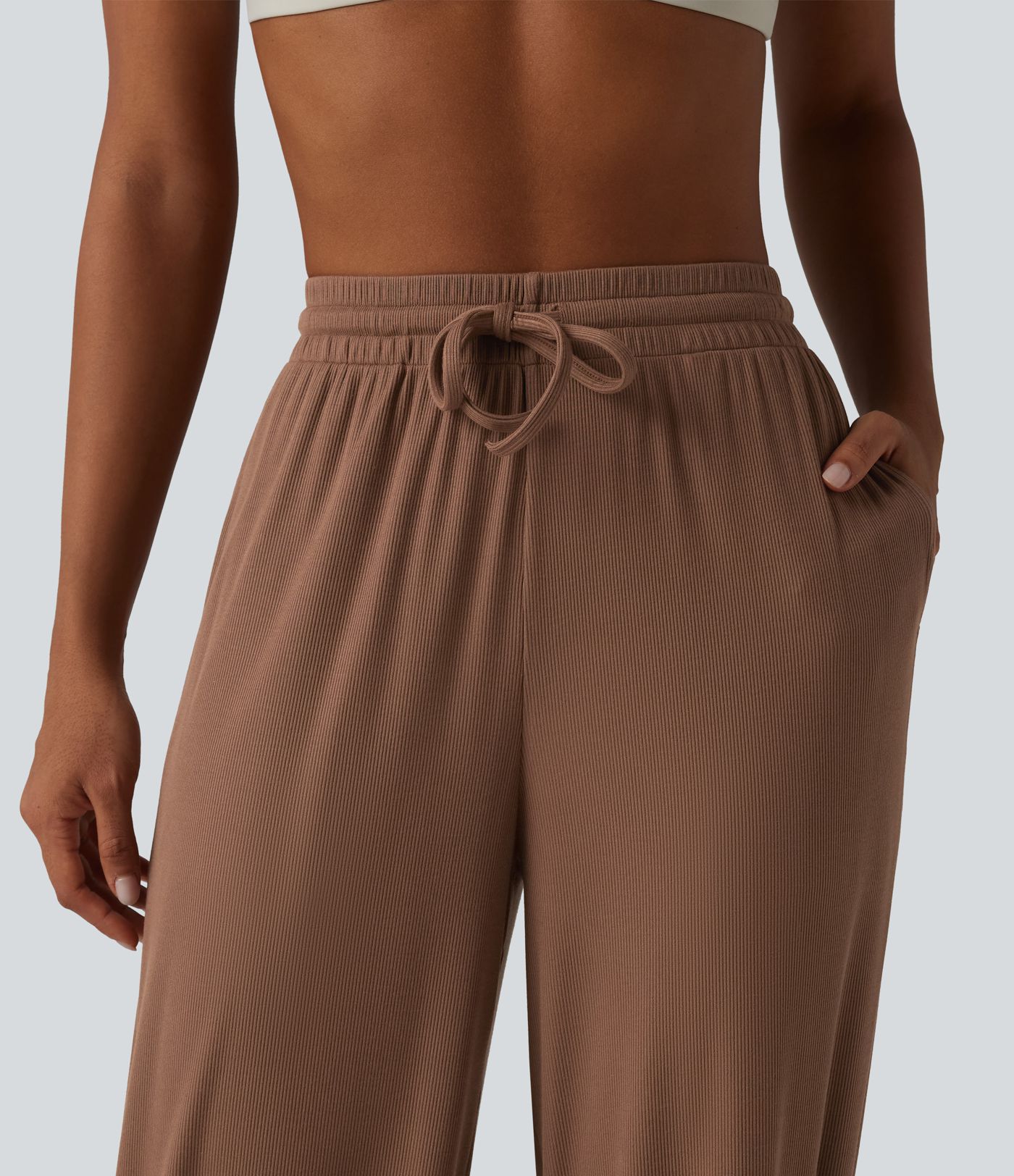 Gathered yoga joggers made from highly elastic ribbed knit with a high waistband, side pockets and drawstring.