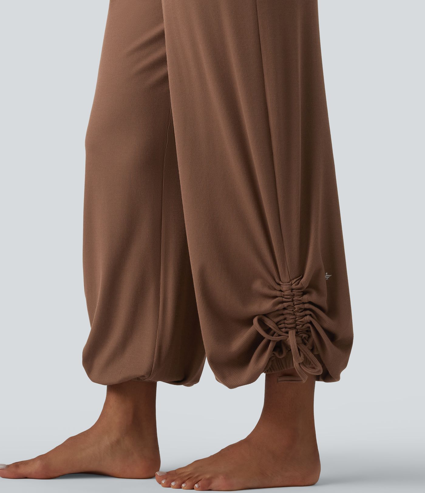 Gathered yoga joggers made from highly elastic ribbed knit with a high waistband, side pockets and drawstring.