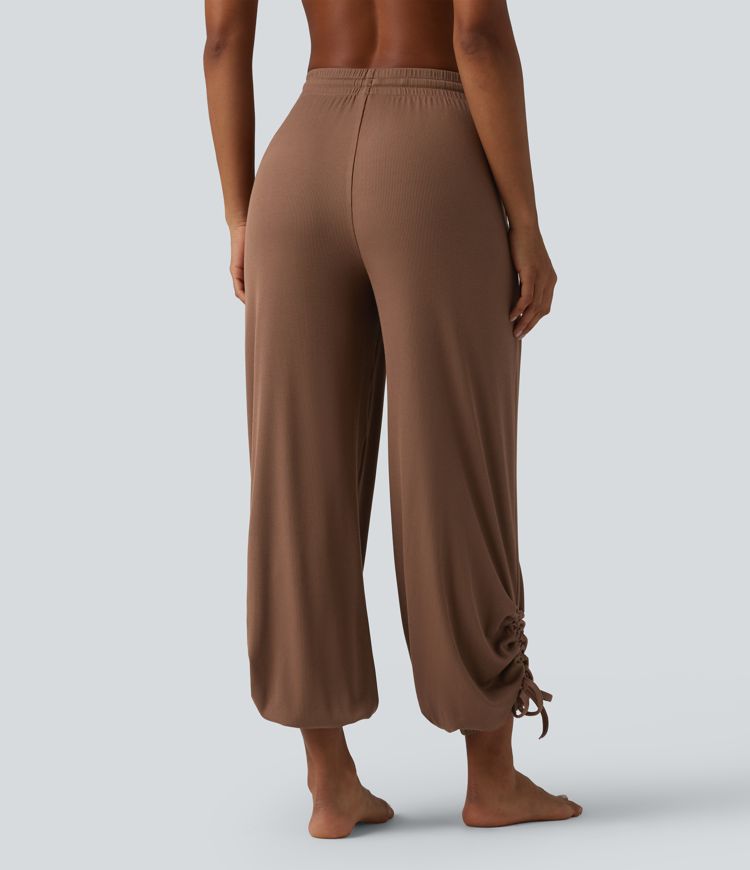 Gathered yoga joggers made from highly elastic ribbed knit with a high waistband, side pockets and drawstring.