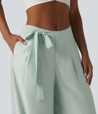 Aukšto liemens, šone surišamomis raišteliais ir laisvo audinio kelnės su kišenėmis