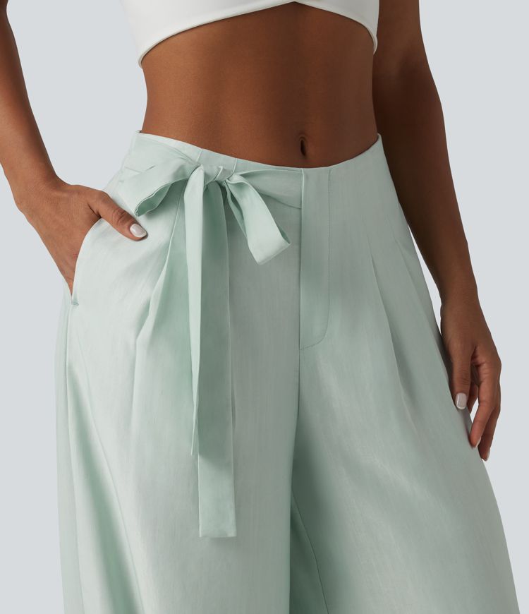 Aukšto liemens, šone surišamomis raišteliais ir laisvo audinio kelnės su kišenėmis