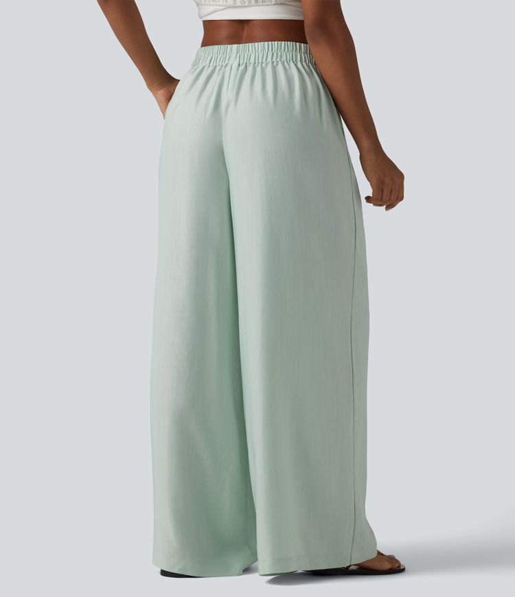 Aukšto liemens, šone surišamomis raišteliais ir laisvo audinio kelnės su kišenėmis