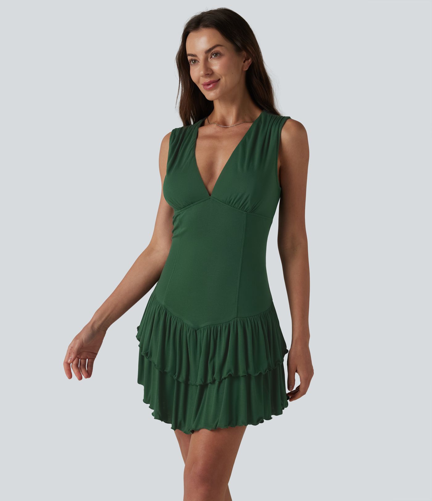 Minivestido sin mangas con cuello en V y volantes superpuestos en el bajo, de punto acanalado.