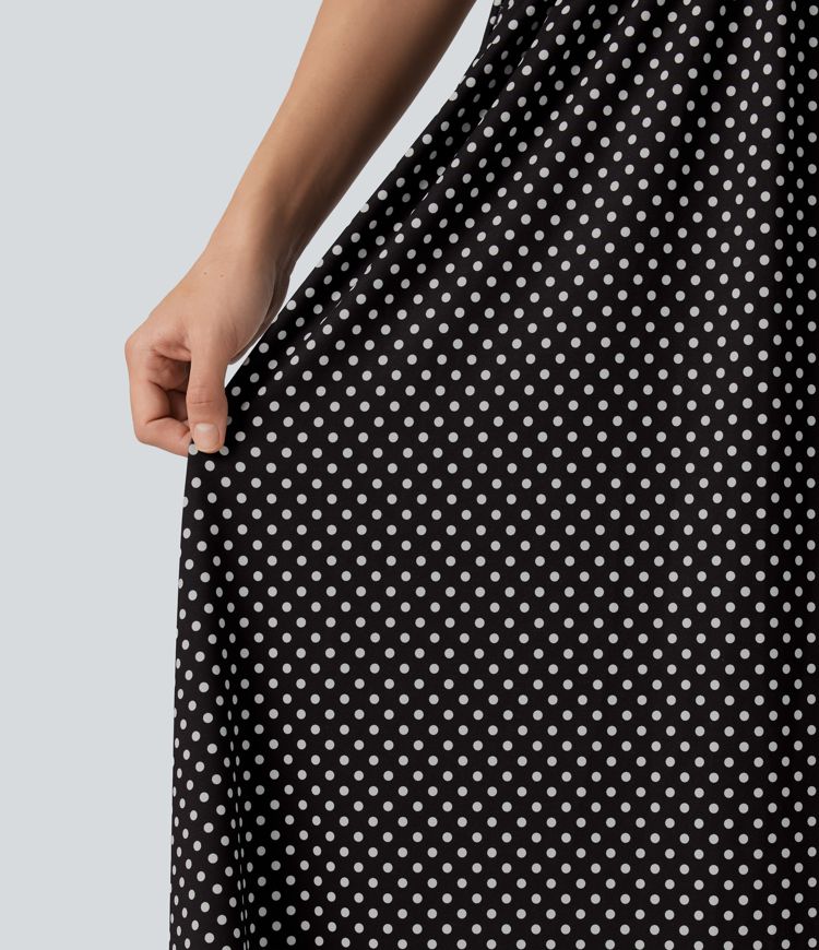 Robe midi fluide et décontractée à pois, sans manches, dos-nu et croisée, avec poches.