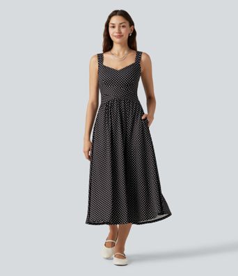 Robe midi fluide et décontractée à pois, sans manches, dos-nu et croisée, avec poches.
