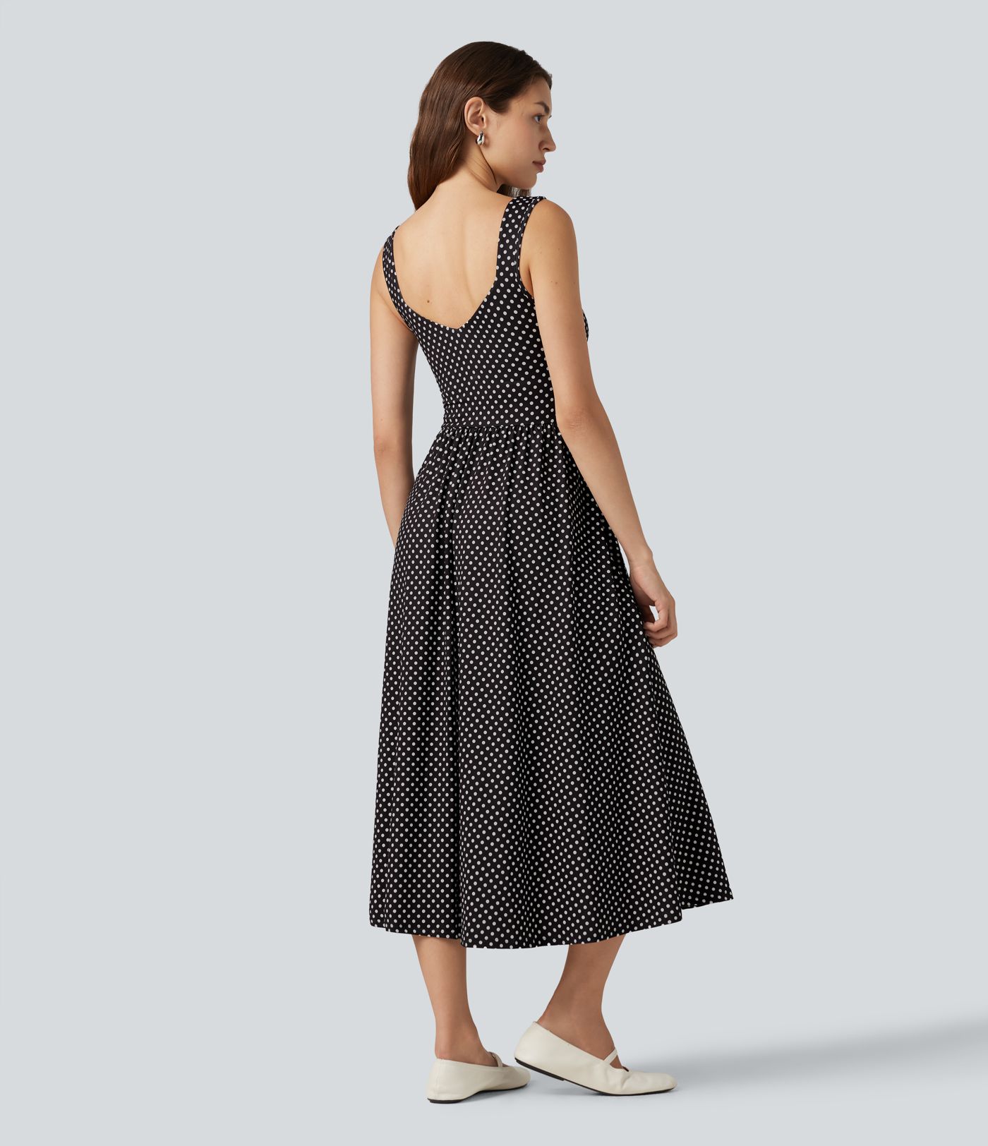 Robe midi fluide et décontractée à pois, sans manches, dos-nu et croisée, avec poches.