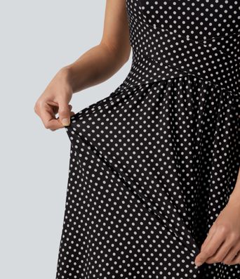 Robe midi fluide et décontractée à pois, sans manches, dos-nu et croisée, avec poches.