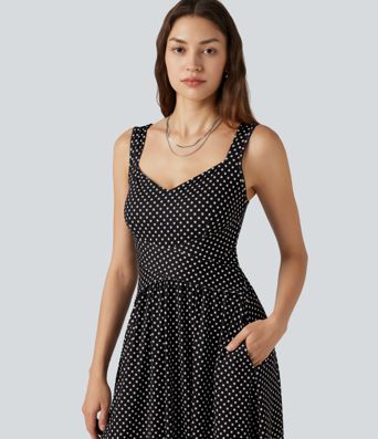 Robe midi fluide et décontractée à pois, sans manches, dos-nu et croisée, avec poches.