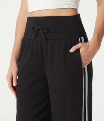 Pantalon baggy décontracté côtelé à taille haute, gainant au niveau du ventre, à cordon de serrage, avec bande latérale et poches.