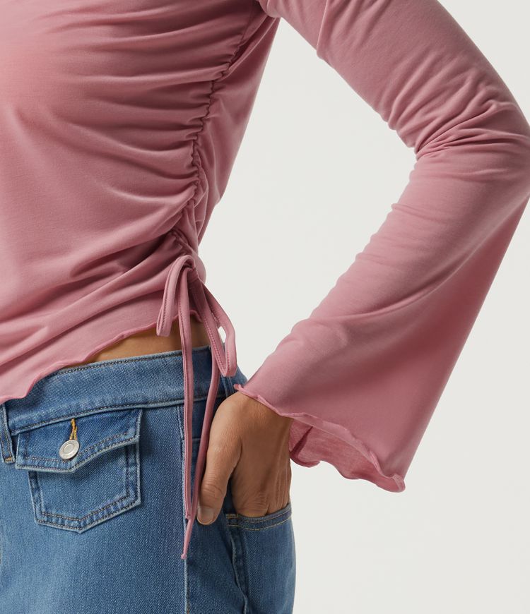 Top casual de cuello barco, manga larga, fruncido asimétrico con ribete ondulado, en tejido de secado rápido. Top casual de cuello barco, manga larga, fruncido asimétrico con ribete ondulado, en tejido de secado rápido.
