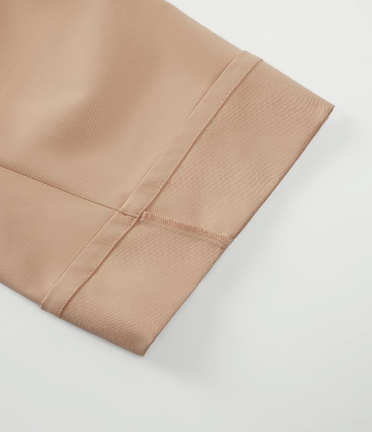 Pantalon décontracté taille mi-haute, jambe en forme de tonneau, ourlet roulotté et poches.