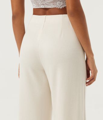 Gerippte Strickhose mit mittelhohem Bund, weitem Bein, schmalen Biesen und Taschen Gerippte Strickhose mit mittelhohem Bund, weitem Bein, schmalen Biesen und Taschen